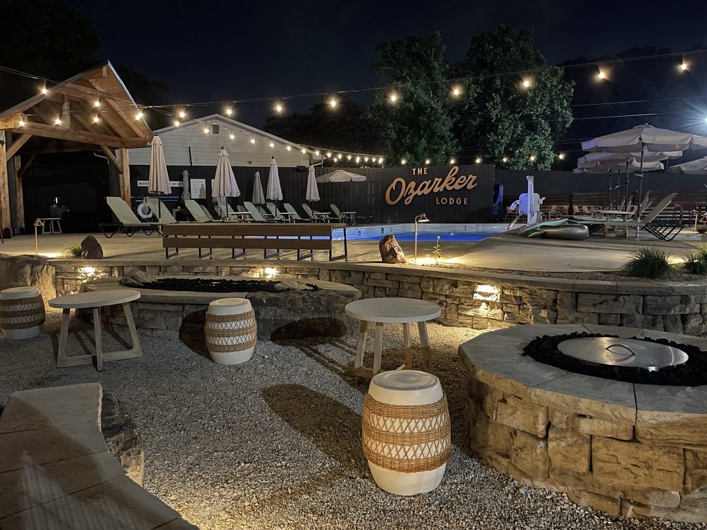 Stone fire pits and a pool deck under string lights