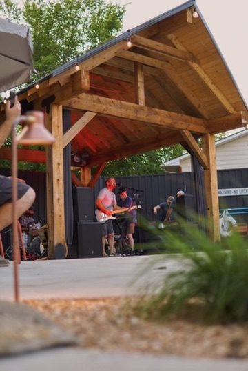A timber pavilion with live music at dusk